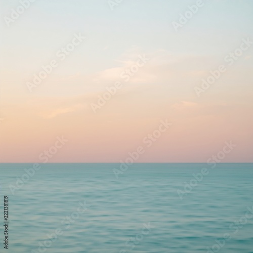 Serene sunset ocean scene with lone boat sailing near horizon