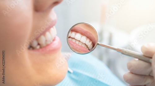 Dentist examining smiling patients teeth with a dental mirror. Oral health checkup and preventive dental care. Dentistry, hygiene and healthy smile concept. Clinical care