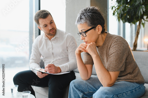 Psychologist listening to mature woman during therapy session