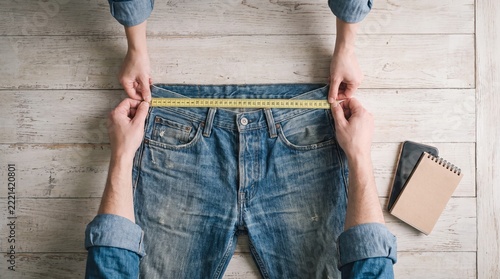 Hands Measuring Vintage Jeans Waist With Tape Measure for Resale Listing