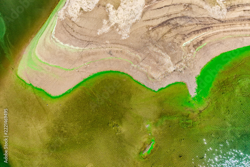 Aerial View of Rocky Shoreline, Low Water Level and Unusual Green Water Patterns in a Reservoir
