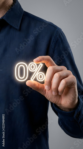 Man in blue shirt holding a glowing zero percent interest or discount symbol in his hand