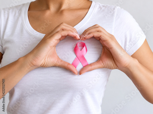 Woman Making Heart Shape with Hands Around Pink Ribbon for Breast Cancer Awareness and Support