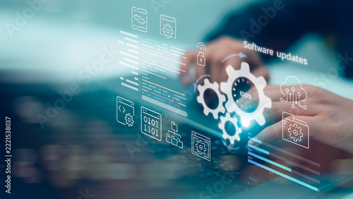 Close up hands of programmer typing laptop for software updates process with gear icon, binary code and digital virtual interface for business information technology development system concept.