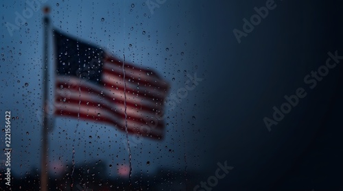 American flag waving behind rainy window glass with water droplets in moody blue lighting