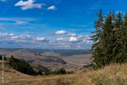 View from the top of the mountain at autumn, small hungarian village in the valley in Transylvania, Romania.