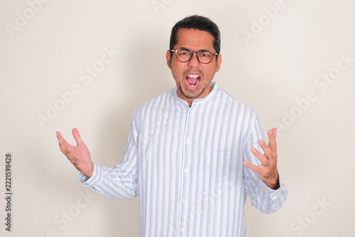 Adult Asian man screaming furious at the camera