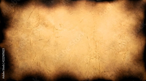 Old vintage parchment paper background with burnt charred edges and copy space