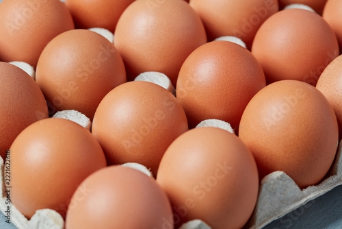 Fresh brown chicken eggs arranged in cardboard carton