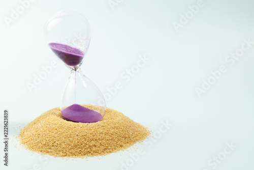 Obraz na plátně Hourglass with purple sand flowing into a pile of brown sand, symbolizing passin
