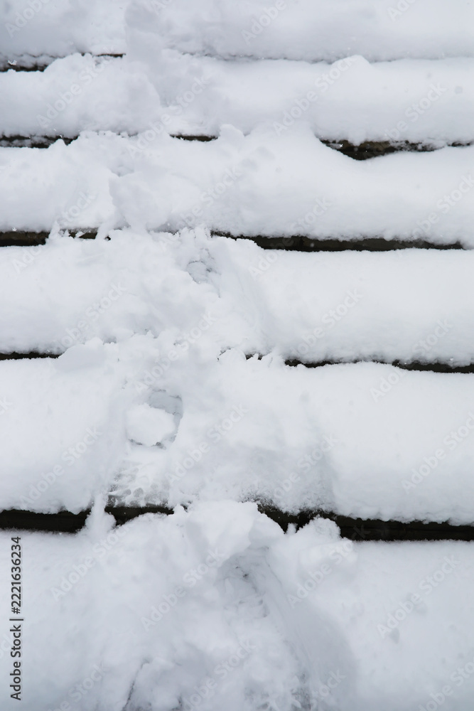 Fototapeta premium Snow-Covered Steps with Footprints in Fresh Winter Snow