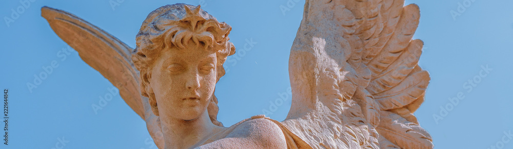 Fototapeta premium Guardian angel with wings and a star against a clear blue sky, symbolizing divine protection, hope, guidance and connection with heaven.