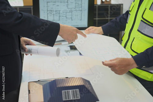 Construction planning collaboration with blueprint and safety vest supporting focused planning and collaboration