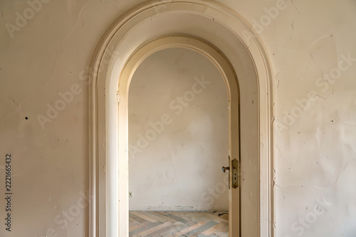 Cream arched doorway with decorative molding in a softly lit interior