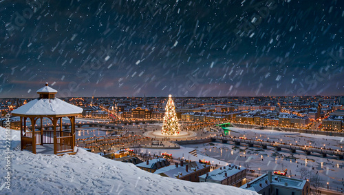 A snowy city panorama glows at night around