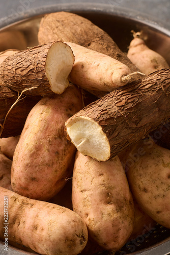 pile of raw cassava and sweet potatoes in bowl, unpeeled root vegetables in close-up view, healthy organic cooking ingredients concept