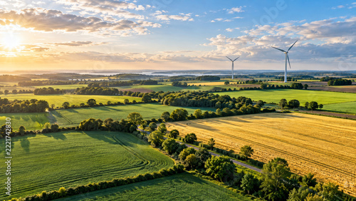Wind turbines across green farmland at golden hour