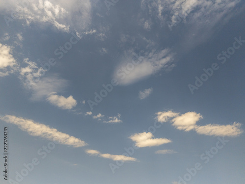 Sky scene showing pale blue background with light fluffy clouds