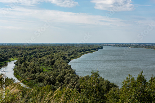 The Siberian river, wide and peaceful, draws bizarre loops between green banks