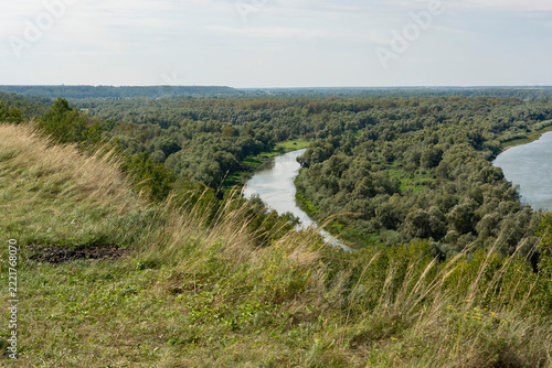 The Siberian river, wide and peaceful, draws bizarre loops between green banks