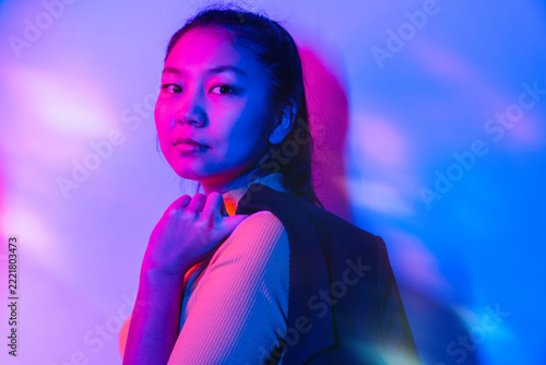 Woman Holding Blazer Under Blue and Magenta Neon Lights