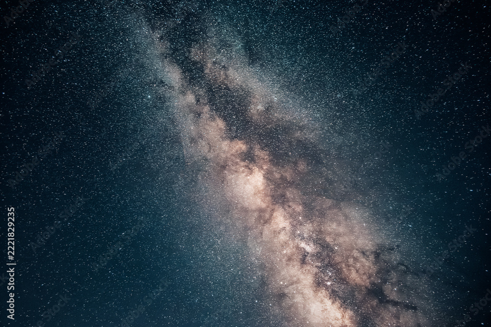 Fototapeta premium Milky Way band of stars and nebulosity stretching across the dark night sky. Astronomy and cosmos background