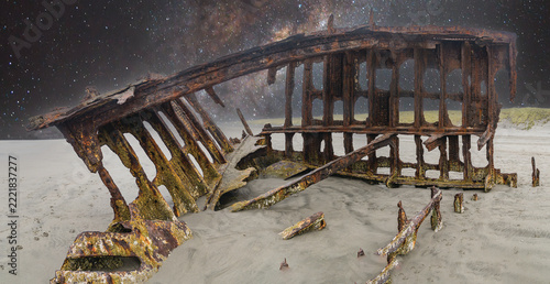 The Peter Iredale, a four masted steel hulled transport ship, built in England, round aground in 1906 and remains on the shore of the Oregon Coast in the Pacific Ocean. with a night sky panoramic.