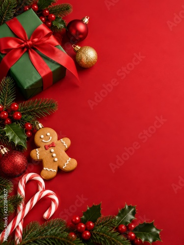 Christmas still life with gingerbread and holiday decorations on red background