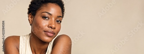 Radiant beauty portrait of woman with natural skin and beige banner space
