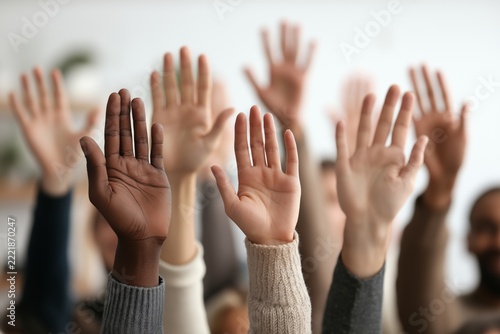 A group of diverse hands raised together, symbolizing collective participation, voting, agreement, and inquiry, representing community engagement, inclusion,  