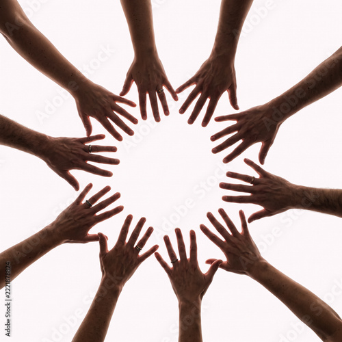Diverse people joining hands in circle showing unity and teamwork