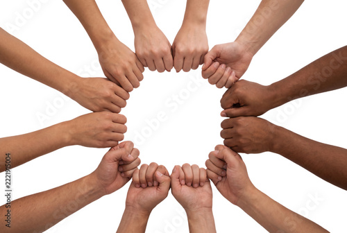 Diverse people joining fists in circle for unity and teamwork