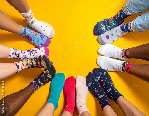 Diverse feet forming a circle, wearing colorful patterned socks, symbolizing individual