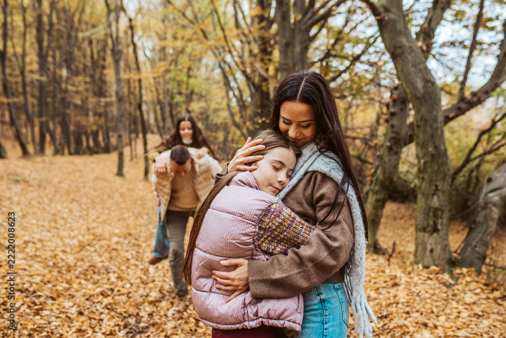 Fototapeta premium Family portrait of parents with two daughter, in the middle of autumn forest.