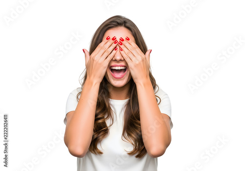 Happy young woman with curly hair covering her eyes with hands and smiling broadly while wearing a simple white casual t-shirt isolated on transparent background