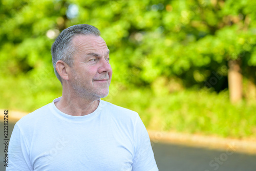 Thoughtful mature man looking sideways outdoors