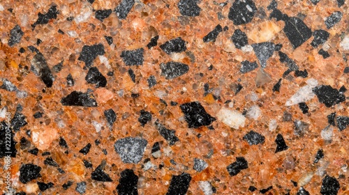 Close-up image of a polished terrazzo surface with black, gray, and brown stone chips embedded in a reddish-brown matrix.