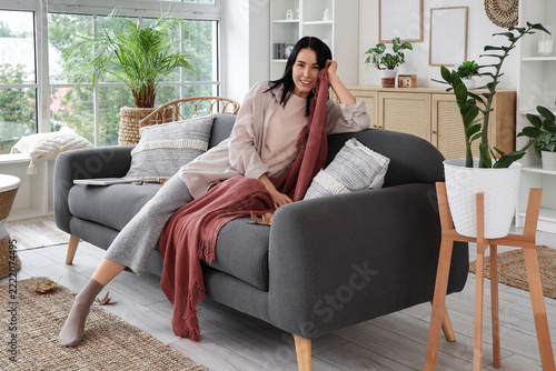 Work-life balance and relaxation, woman resting on a sofa at home with a cozy...