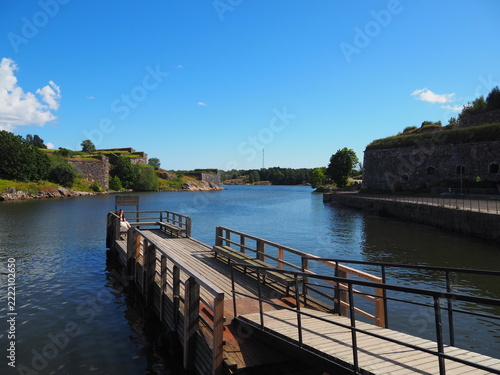 Wooden pier and scenic waterway surrounded by stone walls at Suomenlinna Fortress