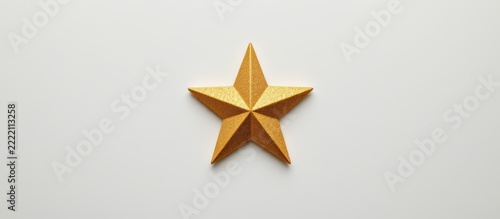 Gold metallic star ornament with textured surface on plain white background
