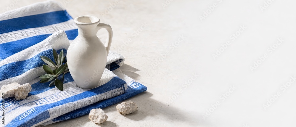 Fototapeta premium Greek still life amphora olive branch and patterned fabric on a bright stone surface background room