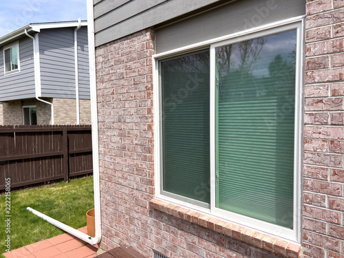 Corner view of house with two brick wall windows