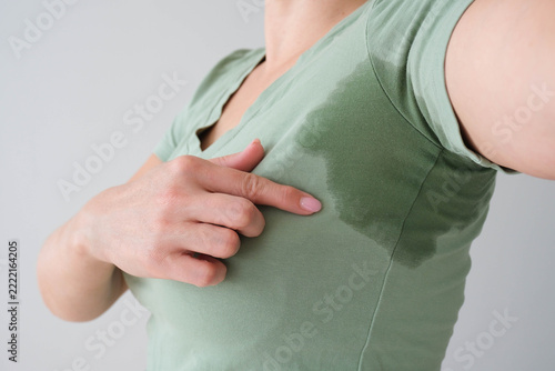 The woman has a wet sweat stain on her T‑shirt.
