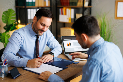 Businessman signing documents during client consultation
