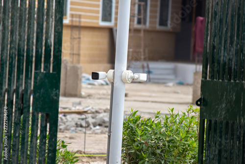 CCTV security cameras mounted on a pole outside a residential building entrance