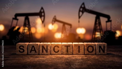 Oil industry sanctions concept with wooden blocks spelling SANCTION and pumpjacks at sunset.