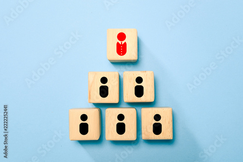 Fotografie Wooden blocks arranged as a team hierarchy with a red manager icon above black team members on a blue background illustrate organizational structure, management, teamwork, and authority