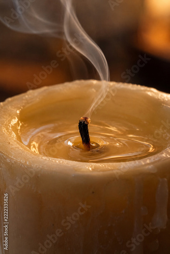 Warm wax ripples beside a newly extinguished candle wick