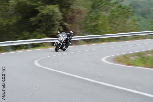 biker on a custom classic motorcycle rides down the road, road traffic