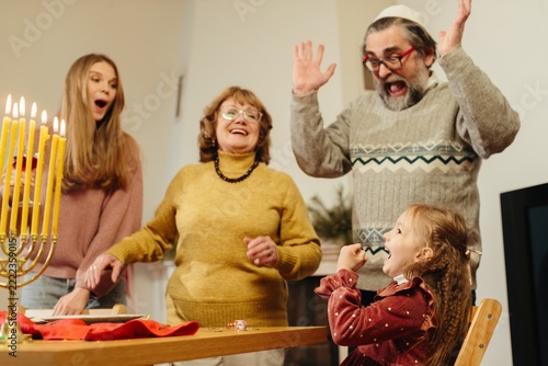 Obraz na plátně Jewish family celebrating hanukkah with menorah and dreidel